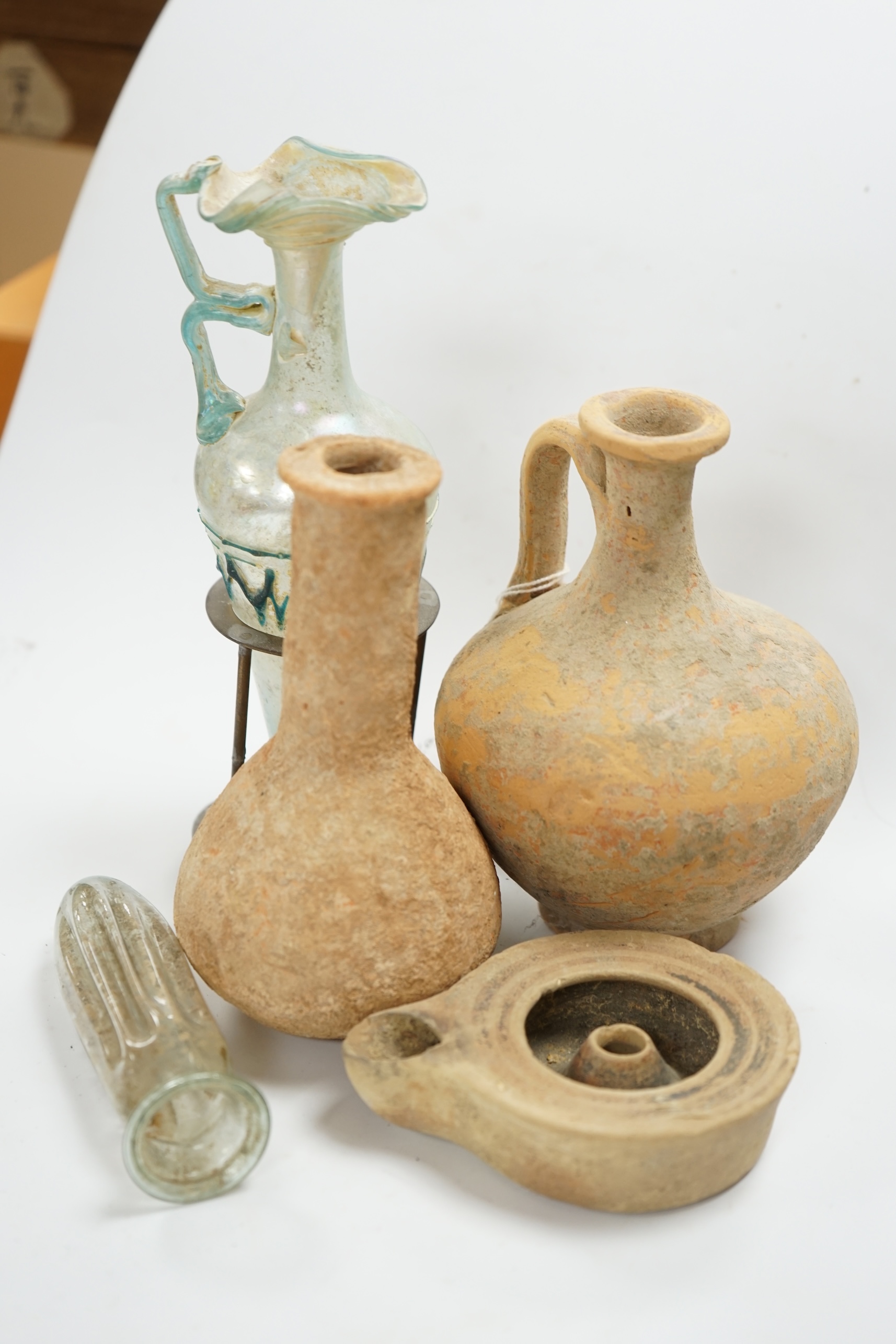 A Roman glass vase on stand, a similar Roman glass vase and three terracotta Syrian style vessels, tallest Roman vase on stand 17cm high (not including stand). Condition - Roman vase on stand cracked at neck, other vase